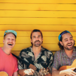 Band Dis M mit Gitarren vor gelber Holzwand