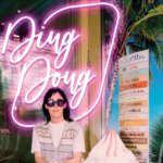Eva Karl Faltermeier mit Sonnenbrille vor Neon-Schriftzug Ding Dong